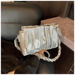 Detail showing the silver pleated cloud bag with woven handle and metallic leather texture