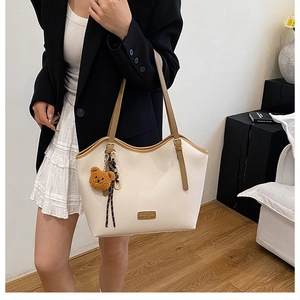 Detail of off-white tote bag with lychee texture and adjustable brown shoulder strap