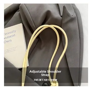 Detail view of the adjustable yellow leather shoulder strap on a chic cloud handbag