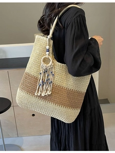 Large woven beach tote bag in beige and brown with tassel charms and rope handles