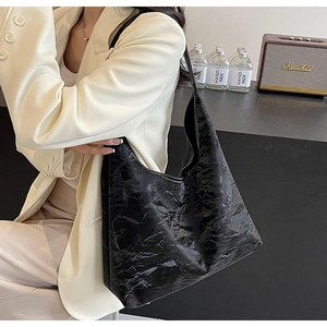 Detail view of black textured leather hobo bag with elegant pleats and large capacity