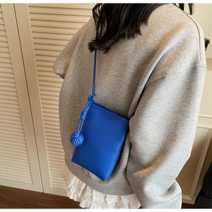 Blue lychee grain leather phone bag with woven ball knot detail and slim shoulder strap