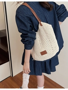 Woven tote bag with slim brown leather straps and square logo patch for summer vacation