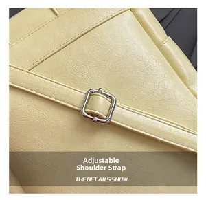 Close-up of adjustable silver buckle on yellow lychee texture leather shoulder strap