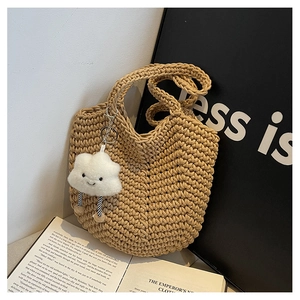 Detail of khaki woven tote bag with a cute cloud plush charm and stylish knited texture