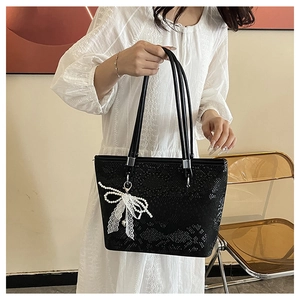 Macro shot of black snake pattern tote bag with pearl lace bow charm detail