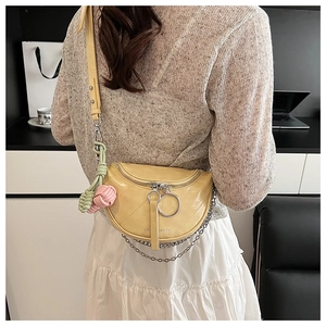 Detail of yellow crescent saddle bag with quilted leather and silver metal chain links