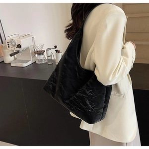 Detail of black wrinkled leather hobo bag showing large capacity and textured shoulder strap