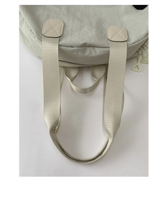 Detail of grey nylon tote bag with reinforced handles, cross stitching and double zippers