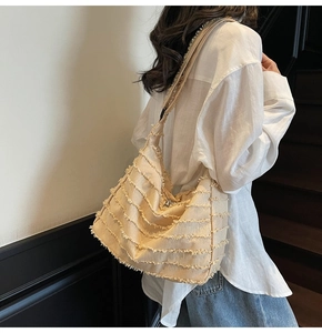 Detail of canvas tote bag with horizontal fringe texture and cream hobo style design