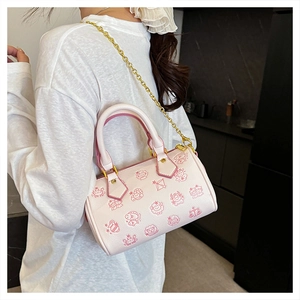 Sac Boston rose avec motifs zodiaque et bandoulière chaîne dorée porté par un modèle