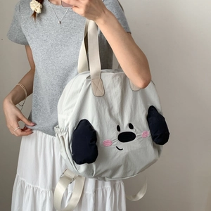 Close-up of white nylon tote bag featuring cute cartoon character and side drawstring pockets