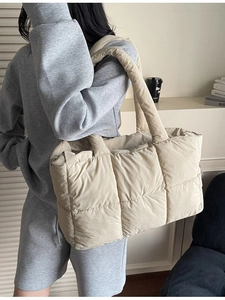 Stylish beige quilted down tote bag with a spacious interior and padded shoulder straps