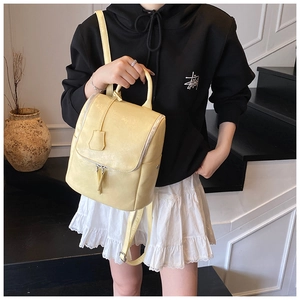 Lifestyle shot of a pale yellow lychee texture backpack on a model in a cozy interior