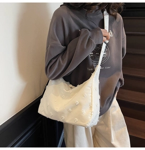 Close-up of a white canvas tote bag with textured fleece fringe and a wide shoulder strap