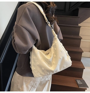Detail of white large canvas tote with embossed floral texture and moon shape