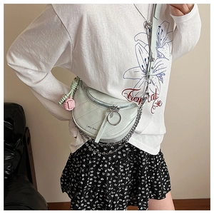 Detail of light green quilted crescent bag featuring Lazy breeze logo and chain