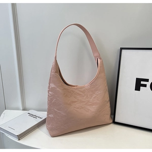 Detail of pink pleated tote bag with wrinkled texture and glossy minimalist shoulder strap
