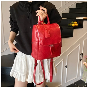 Detail of red textured PU leather mini backpack with dual zippers and handle