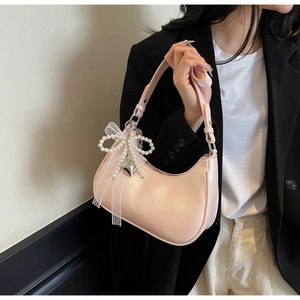 Detail der rosa Hobo-Tasche mit Perlenbogen, Spitzenschleife und Herzanhänger