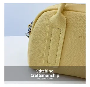 Macro detail of fine stitching and silver metal zipper on light yellow leather pillow bag