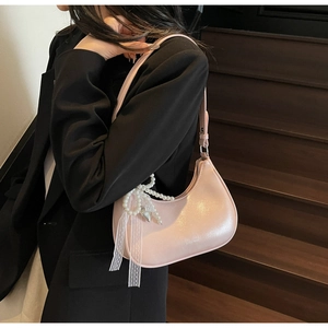 Rosa Perlmutt-Hobo-Tasche mit Spitzenschleife und Perlenkette getragen über schwarzem Blazer