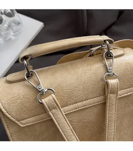 Detail of beige shoulder bag showing silver hardware and crinkled leather texture