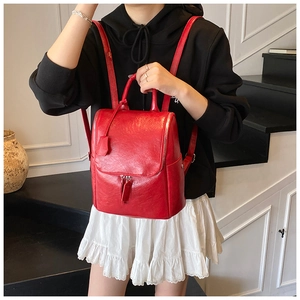 Detailed view of a red lychee pattern leather backpack on a model in a modern interior