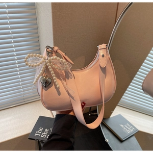 Detail der hellrosa Hobo-Tasche mit Perlenkette, Spitzenbogen und Herzanhänger