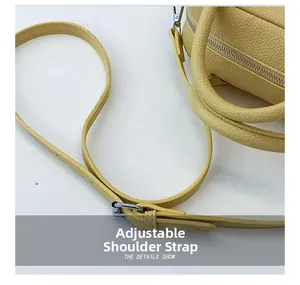 Detail of yellow lychee grain leather handbag featuring adjustable shoulder strap and silver buckle