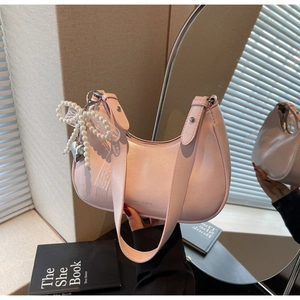 Detail der rosa Hobo-Bag mit Perlen-Schleife und Herz-Anhänger gespiegelt im Spiegel