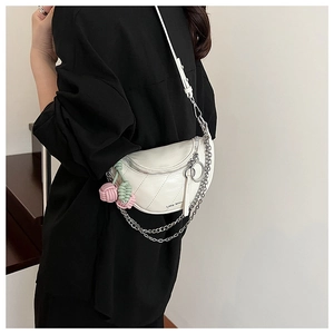 Detail of white PU leather saddle bag with quilted texture and cherry bag charm