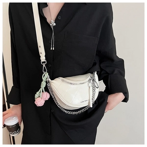 Close-up of semi-circle crossbody bag with chain detail and cherry charm on model
