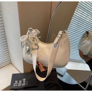 Detail der weißen Hobo-Tasche mit Perlenbogen, Spitzenbesatz und silbernem Herzanhänger