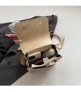 Interior view showing large capacity and cream textured leather of this women's shoulder bag