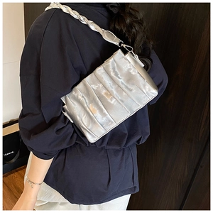 Close-up of silver pleated underarm bag with thick woven chain strap detail