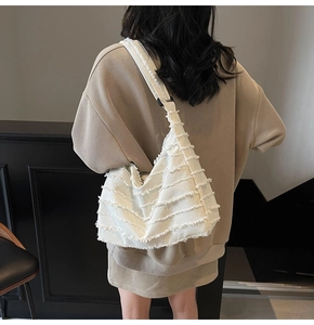 Detailed view of white canvas tote bag with unique frayed edges and fringe layers