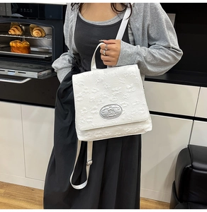 Nahaufnahme weißer Nylon Rucksack mit gestepptem Blumenmuster und Metallverzierung