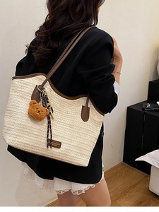 Beige woven straw tote bag with brown leather trim and cute bear charm pendant