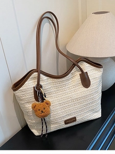 Large woven tote bag in cream straw with brown leather handles and cute bear charm