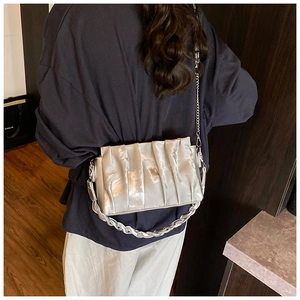 Detail of silver pleated crossbody bag with chunky metal chain and satin finish