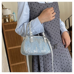 Detail of light blue sequined handbag with silver handles shown in a lifestyle setting