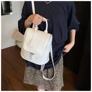 Fashionable white leather backpack with silver zippers worn by a model in casual setting