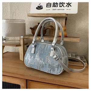 Detail of light blue denim Boston bag with silver sequins and metallic handles