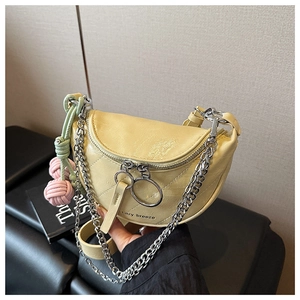 Detail of yellow patent leather saddle bag with quilted pattern and chain strap