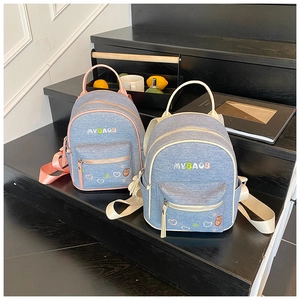 Detail view of mini denim backpacks with colorful piping and cute bear embroidery