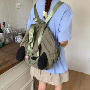 Detail of dark green nylon backpack with cute cartoon dog design and adjustable straps