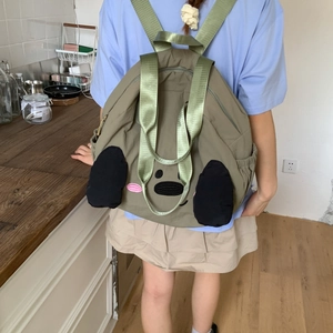 Detail of army green nylon backpack with 3D cartoon ears and embroidered animal face