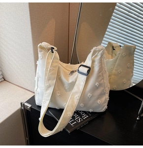 Detail view of white canvas tote bag with 3D flocking dots and adjustable strap