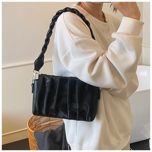 Detail of ruched black faux leather shoulder bag featuring braided strap and metal hooks